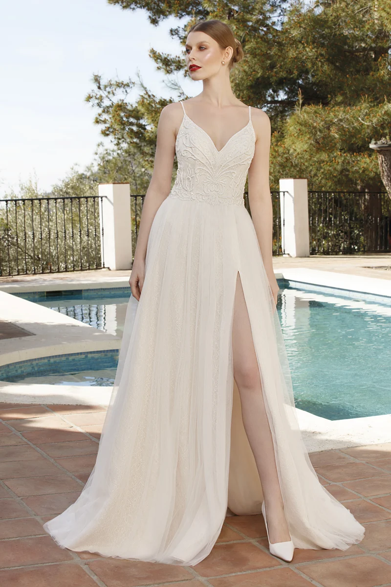 Sposa a figura intera con abito dalla linea scivolata e spacco laterale