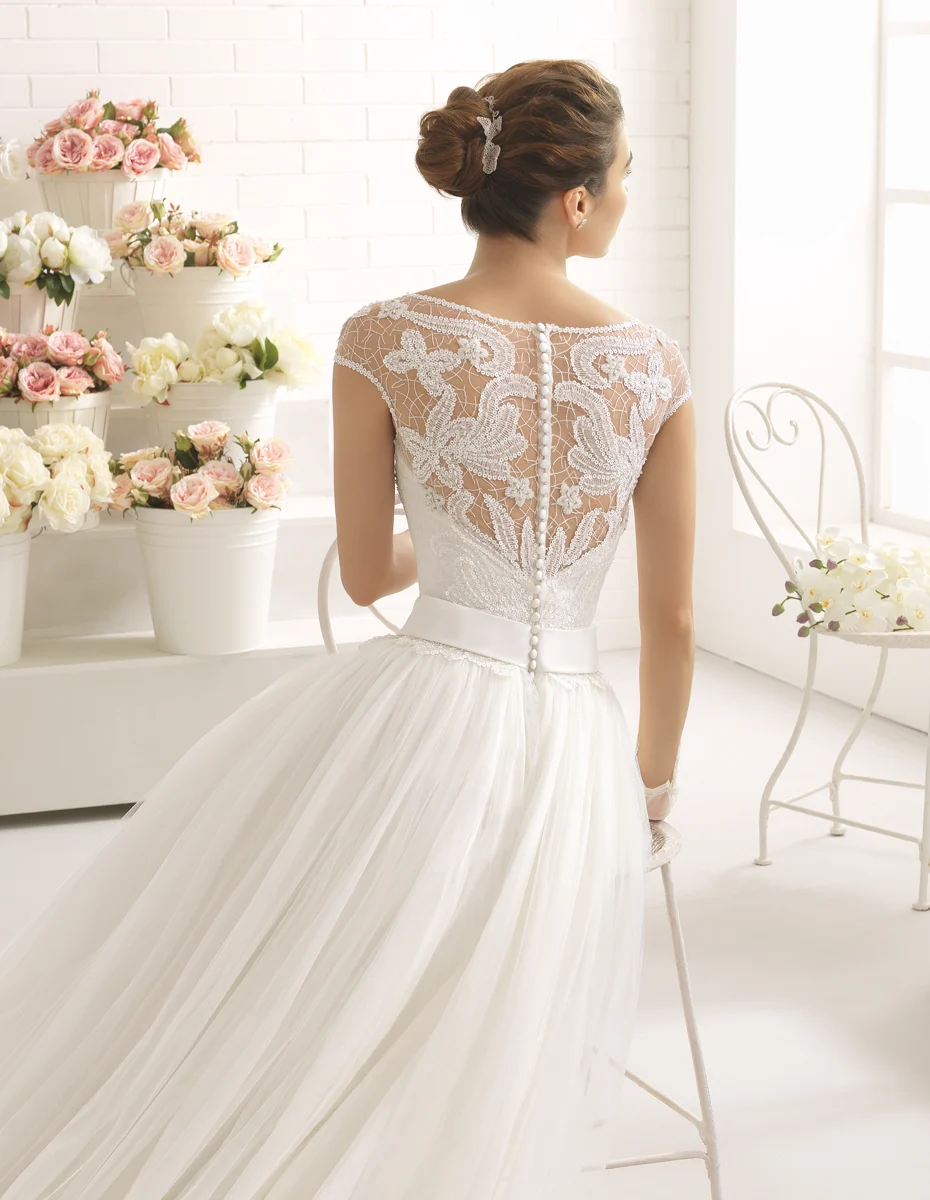 Dettaglio posteriore di un abito da sposa con corpetto in pizzo e fila di bottoni