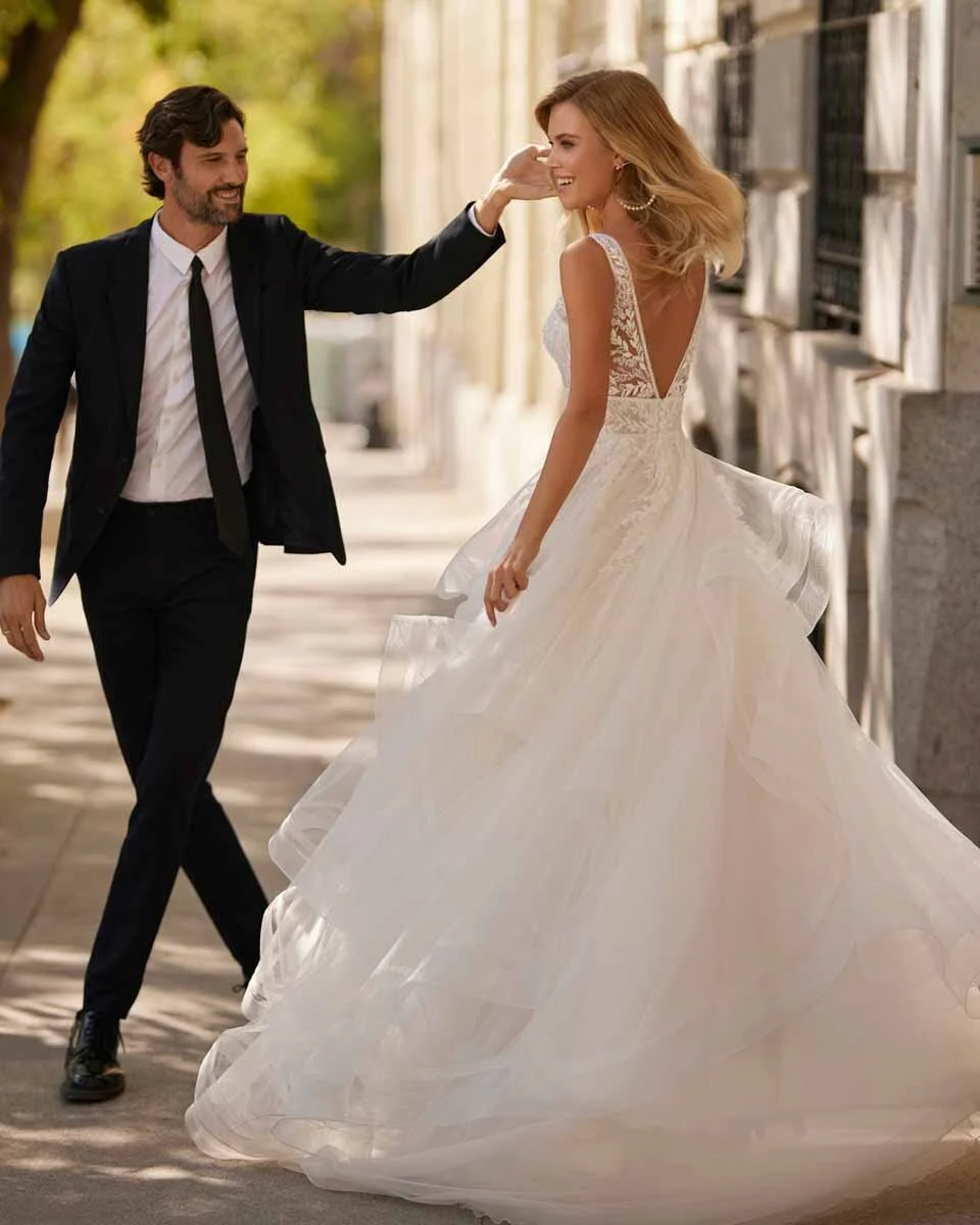 Sposa con abito dalla gonna ampia mentre si gira accanto allo sposo