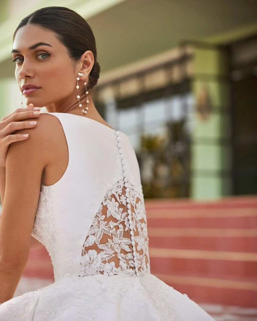 Dettaglio posteriore di un corpetto da sposa con bottoni e inserto in pizzo